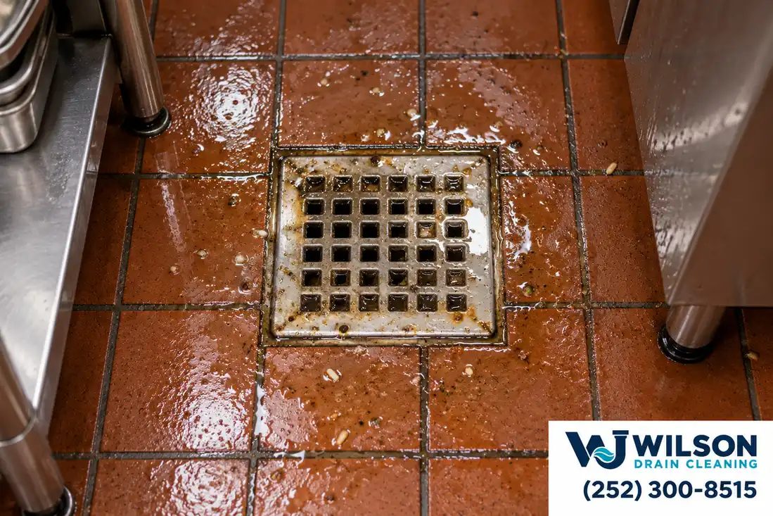 Before view: Restaurant quarry tile floor drain with square stainless grate.